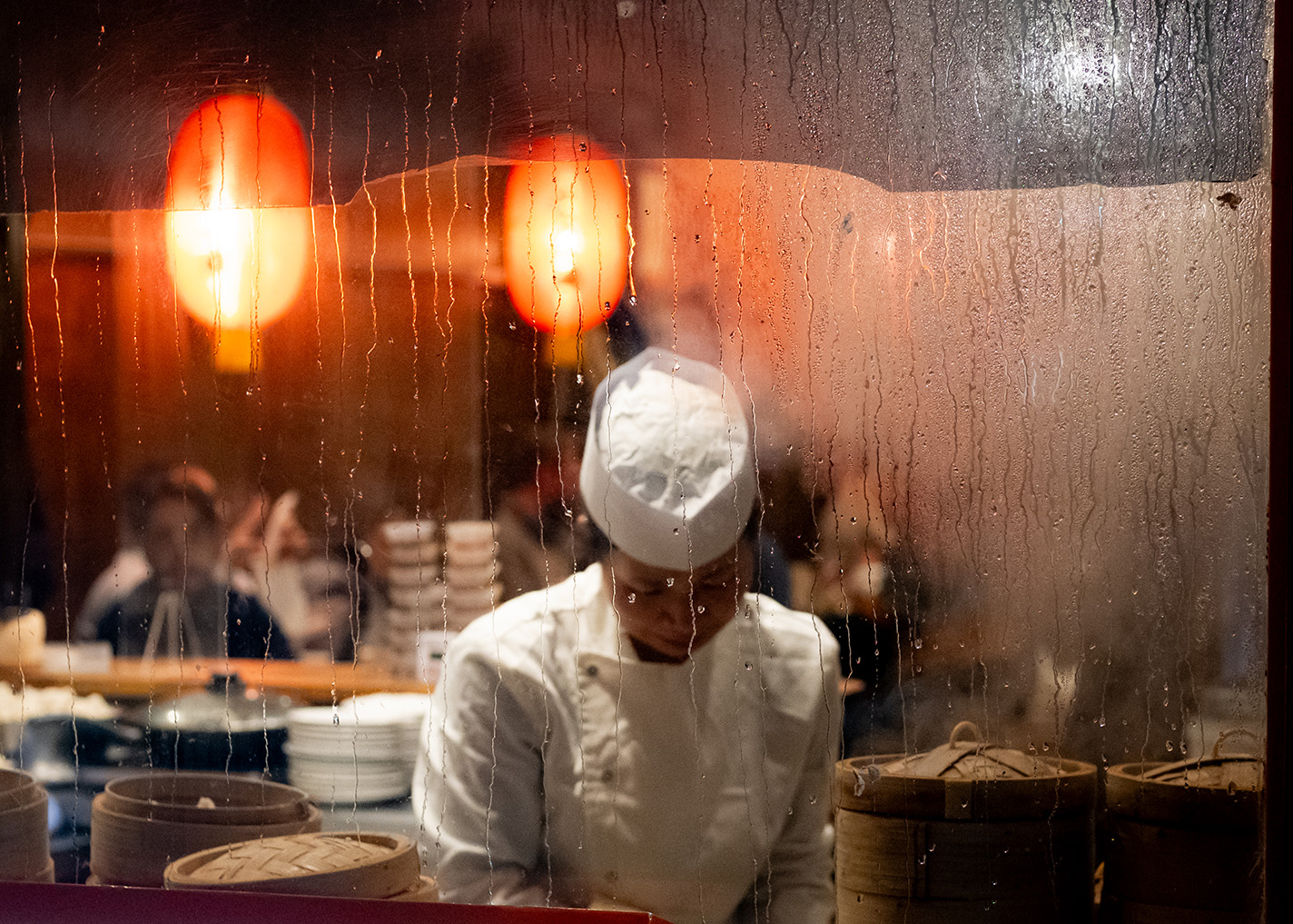 China Town - women chef seen through misted window.