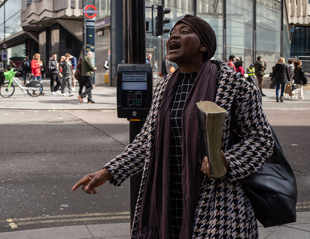 Woman street preacher holding the Bible, Tottenham Court Road, London.