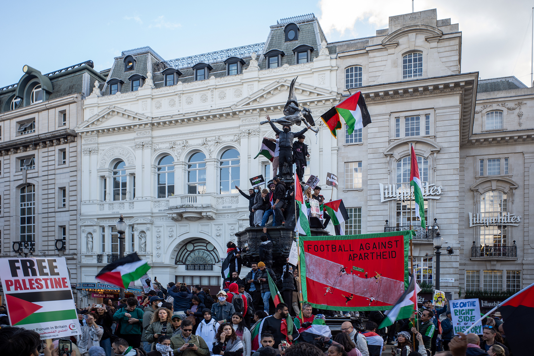 Pro Palestinian protesters climb Eros (Shaftesbury Memorial Fountain), at Piccadilly Circus, London.